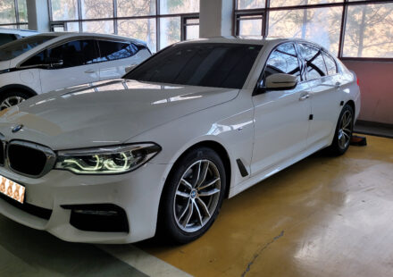 주차장에 세워진 흰색 BMW 520d G30 전면 측면 외관