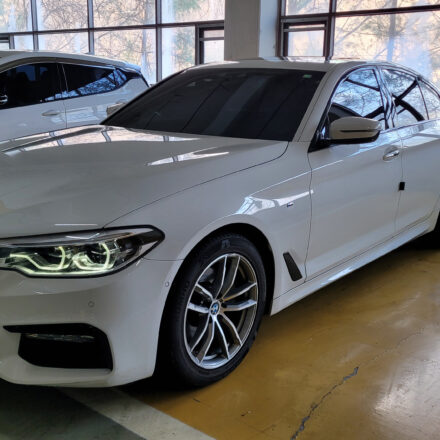 주차장에 세워진 흰색 BMW 520d G30 전면 측면 외관