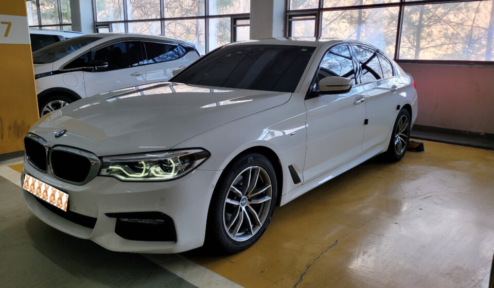 주차장에 세워진 흰색 BMW 520d G30 전면 측면 외관