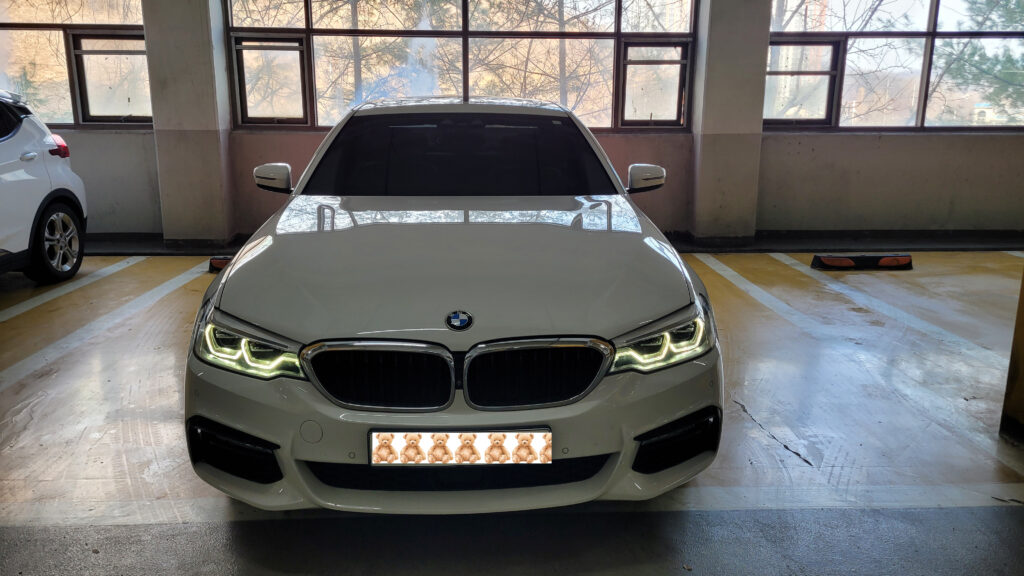실내 주차장에 세워진 흰색 BMW 520d G30 정면