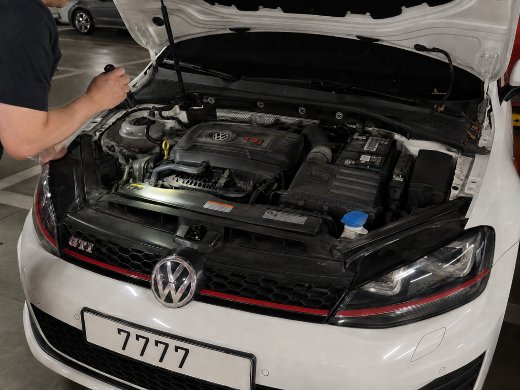 보닛을 열고 엔진룸 상태를 확인하는 흰색 7세대 골프 GTI